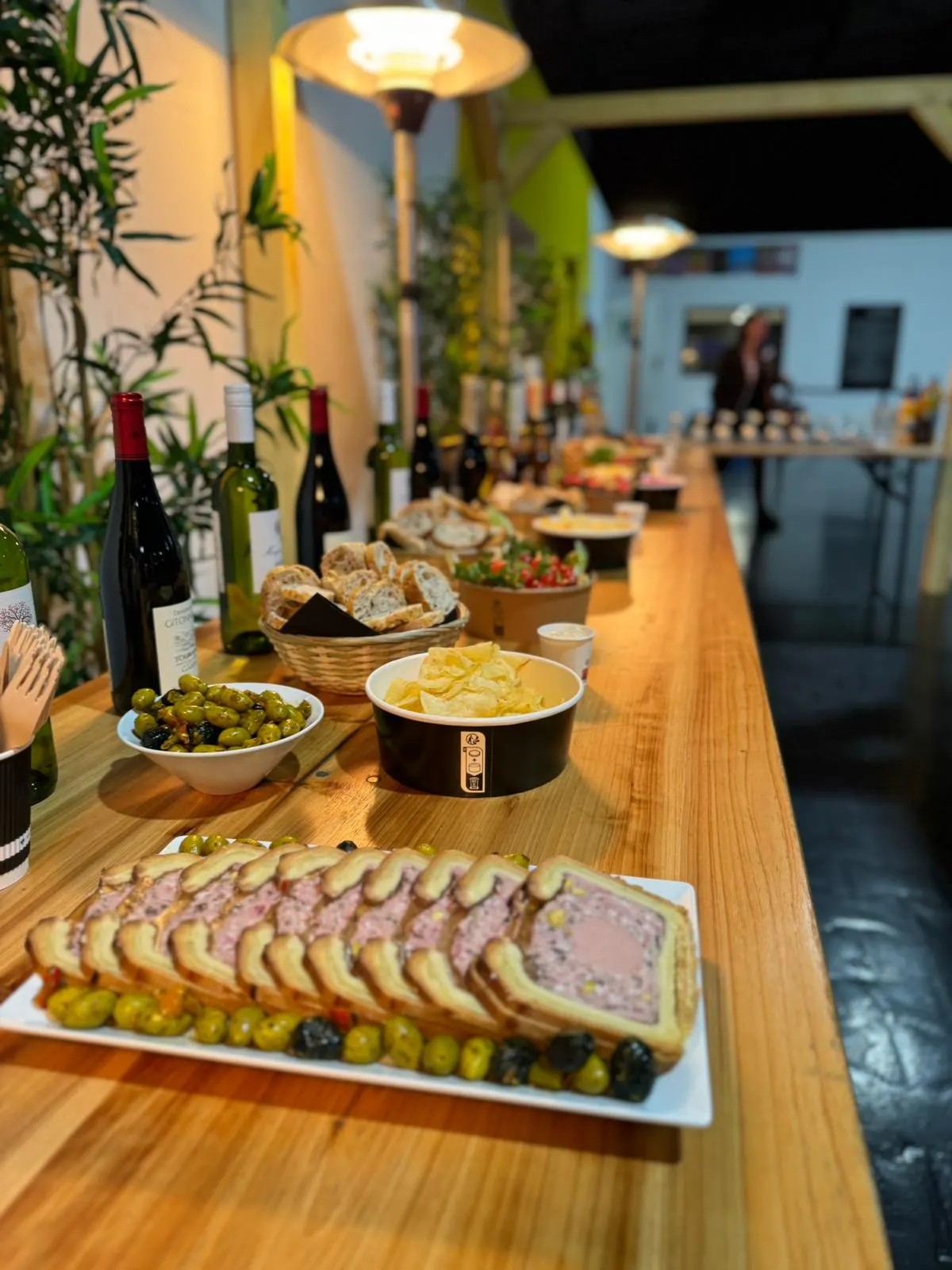 Buffet dressé sur un long comptoir en bois dans l’espace réception du parc