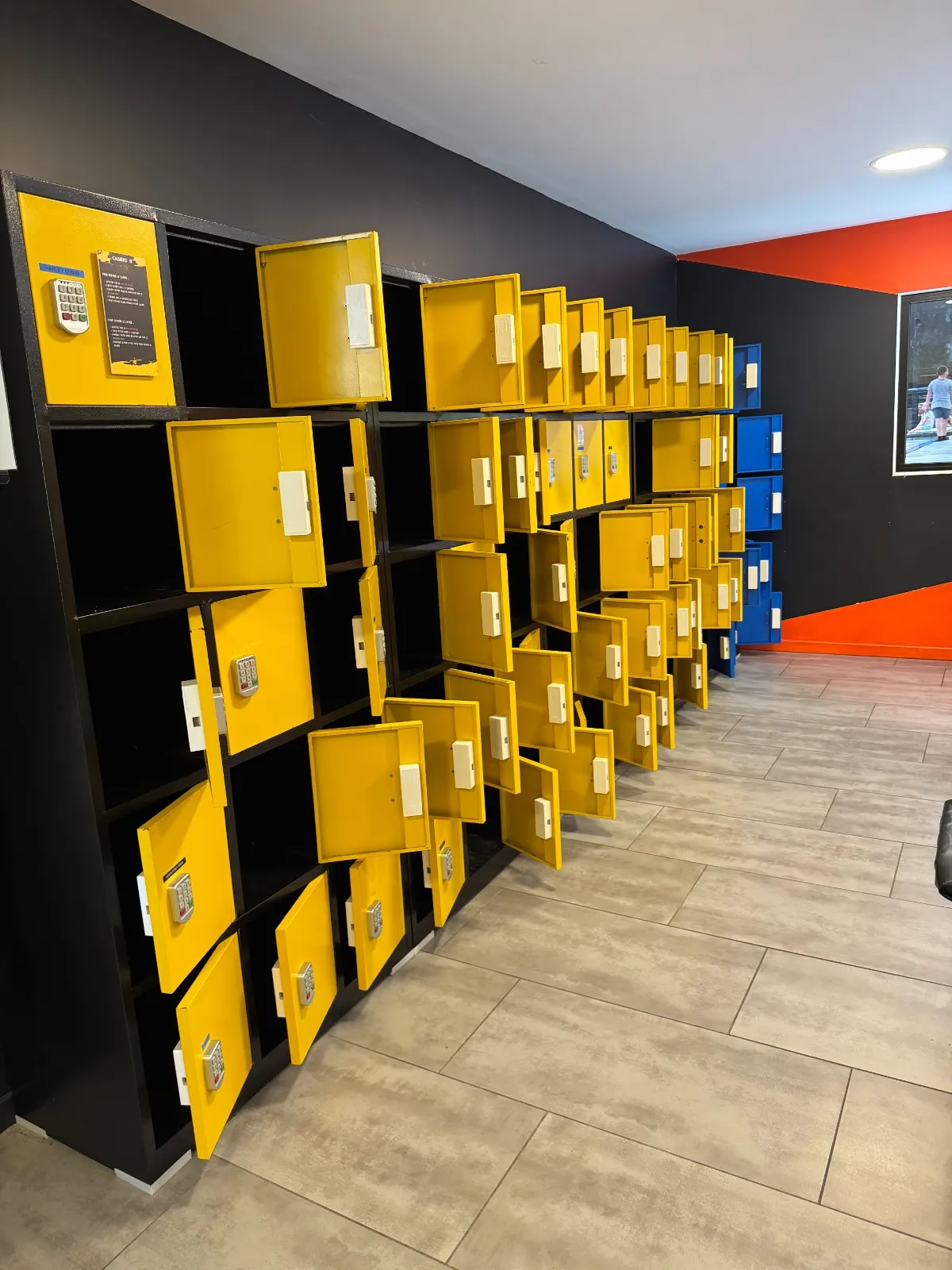 Rangées de casiers jaunes et noirs dans les vestiaires de We Fly