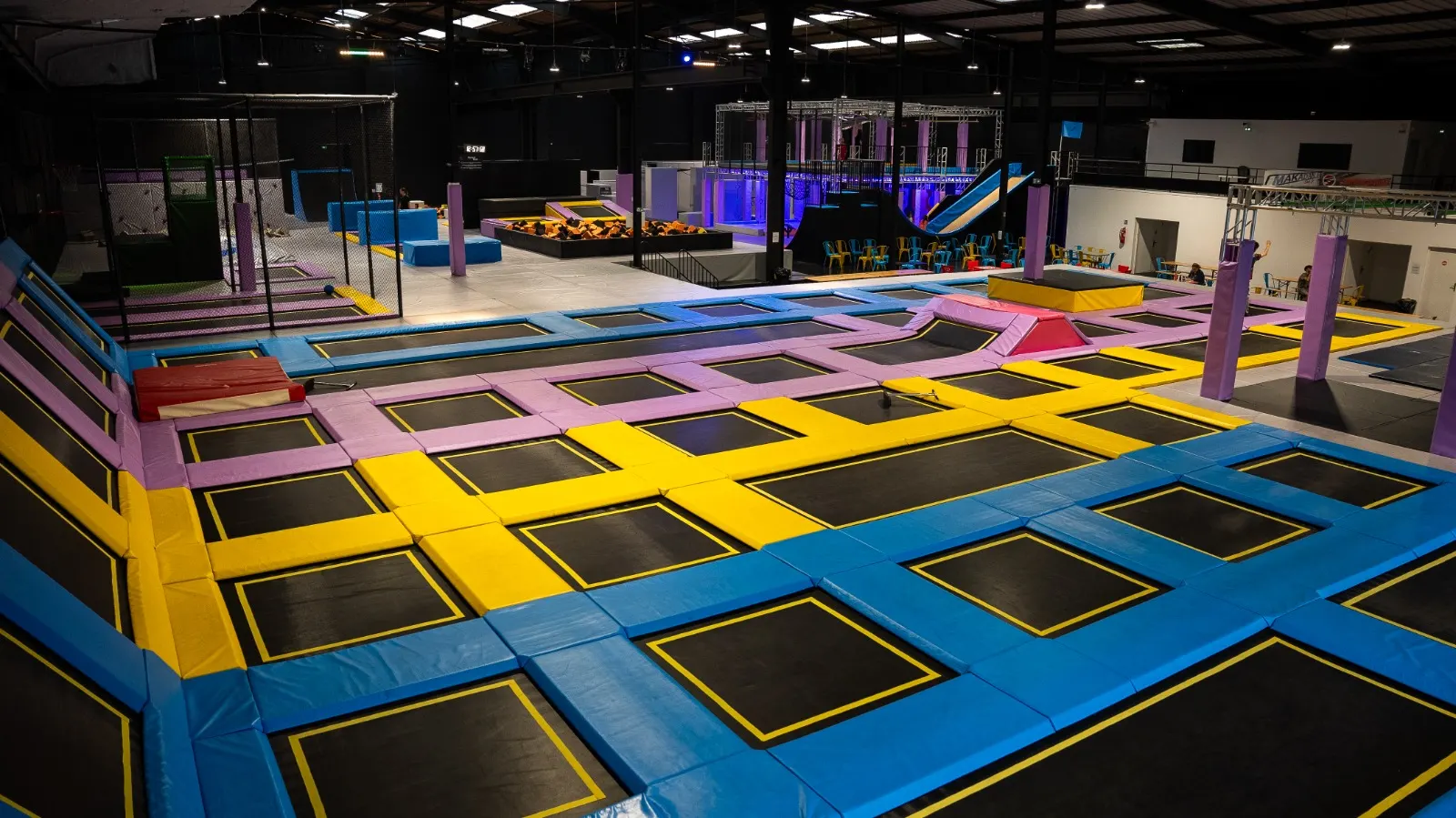 Vue panoramique des trampolines colorés et des espaces d’activité de We Fly