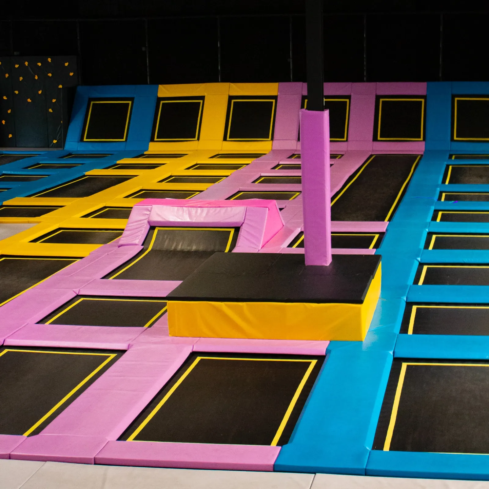 Trampolines jaunes, bleus et violets et plateformes de saut dans le parc We Fly